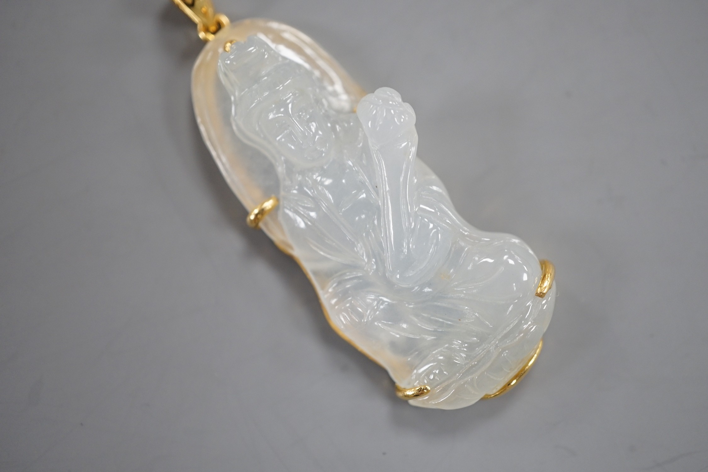 A modern 18k mounted carved jade figural pendant, overall 5cm, gross weight 10.8 grams.